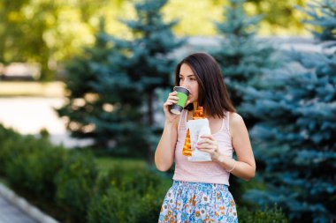 Pizza, onun elinde kahve yemek bir genç kadının portresi. Mockup ürünler sunumları, logo ve metin için. Yaşam tarzı.