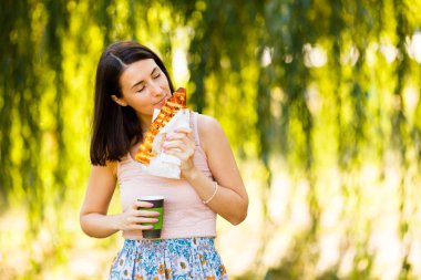 Pizza, onun elinde kahve yemek bir genç kadının portresi. Mockup ürünler sunumları, logo ve metin için. Yaşam tarzı.