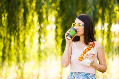 Pizza, onun elinde kahve yemek bir genç kadının portresi. Mockup ürünler sunumları, logo ve metin için. Bir yaşam tarzı. Marka mockup sahne.