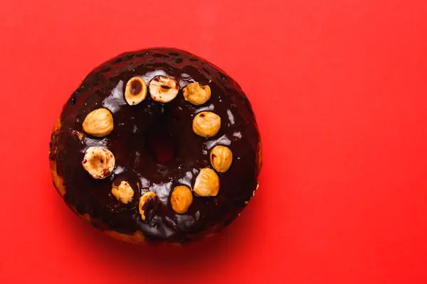 Chocolate donut stock images. Donut on a red background. Donut isolated on a red background. Chocolate with hazelnut donuts