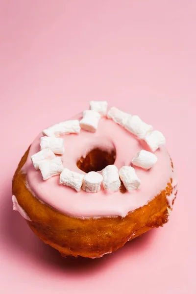 Pink donut with marshmallows on a Pink background