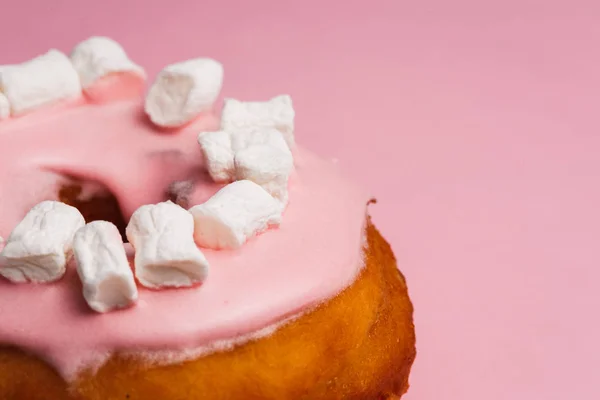 Pink donut with marshmallows on a Pink background