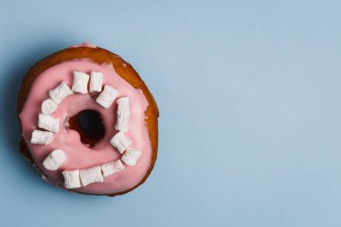 Mavi bir arka plan üzerinde marshmallow ile pembe çörek