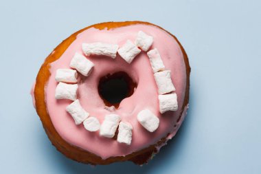 Mavi bir arka plan üzerinde marshmallow ile pembe çörek