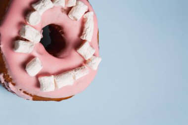 Mavi bir arka plan üzerinde marshmallow ile pembe çörek