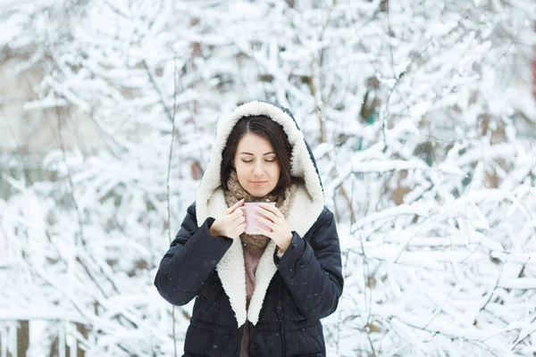 Linda chica con una taza de café rosa en el bosque de invierno — Foto de Stock