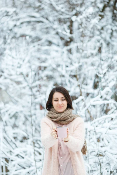 Linda chica con una taza de café rosa en el bosque de invierno — Foto de Stock