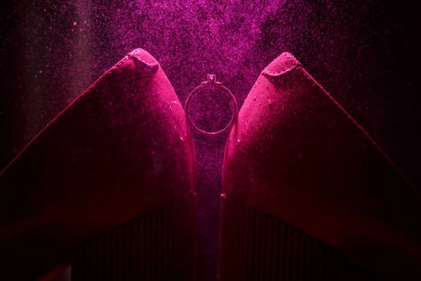 Anillo de compromiso sobre fondo violeta con efecto de pequeñas salpicaduras de agua — Foto de Stock