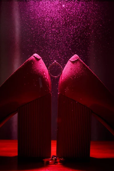 Anillo de compromiso sobre fondo violeta con efecto de pequeñas salpicaduras de agua — Foto de Stock