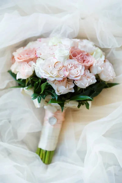 Весільні золоті кільця з пастельною рожевою трояндою — стокове фото