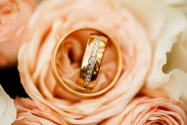 Gouden ringen van het huwelijk met pastel roze roos — Stockfoto