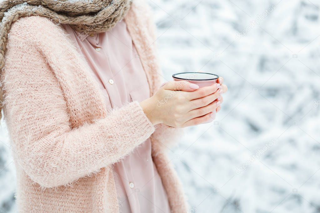Beautiful female hands holding big pink cup of coffee