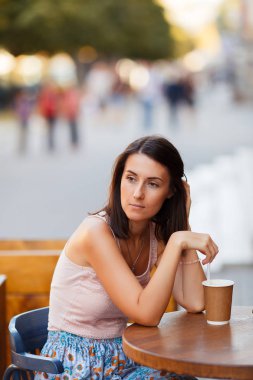 Bir yaz teras bir Cafe de oturup bir sıcak kahve ile güzel bir gülümseyen mutlu Bayan portresi. Genç bir kız oturuyor ve bir restoran masada kahve içme.