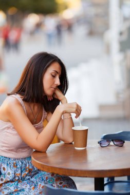 Bir yaz teras bir Cafe de oturup bir sıcak kahve ile güzel bir gülümseyen mutlu Bayan portresi. Genç bir kız oturuyor ve bir restoran masada kahve içme.