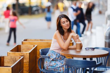 Bir yaz teras bir Cafe de oturup bir sıcak kahve ile güzel bir gülümseyen mutlu Bayan portresi. Genç bir kız oturuyor ve bir restoran masada kahve içme.