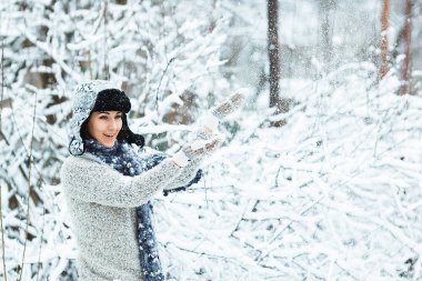 Güzel kız kış ormanda düşen kar ile çalış
