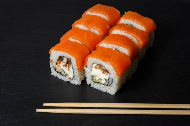 Somon ile Philadelphia rulo suşi, avokado, krem peynir siyah taş kayrak servis