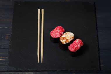 Gunkan Maki Sushi üzerinde bambu Suşi çubukları ile siyah kayrak
