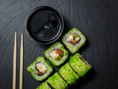 Ton balığı ve krem peynir ile Japon suşi rulo siyah taş arduvaz servis