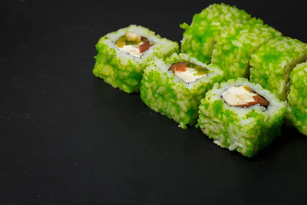 Rolos de sushi japoneses com atum e creme de queijo servido em ardósia de pedra preta — Fotografia de Stock
