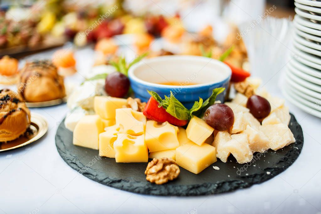 Cheese plate served with fruit and honey