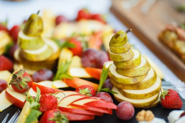 Tatil masasında taze dilimlenmiş meyveler