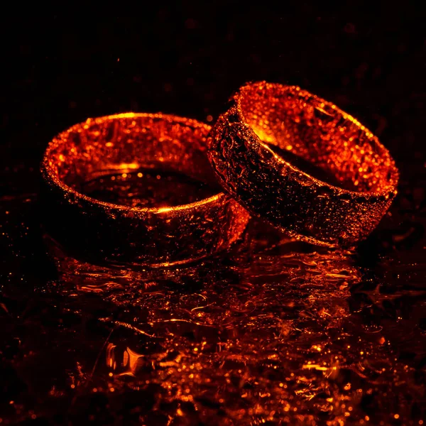 Belos anéis de casamento de ouro com gotas de água — Fotografia de Stock