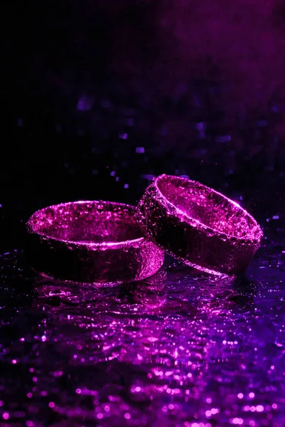 Beautiful wedding rings with violet neon lights — Stock Photo, Image