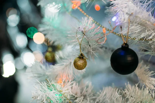 Beyaz kabarık Noel ağacında altın ve siyah Noel topları — Stok fotoğraf