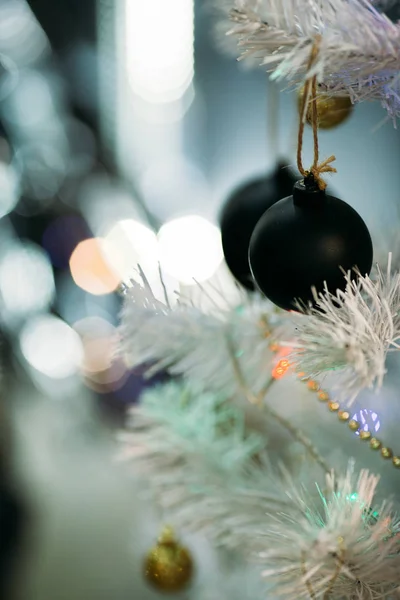 Gouden en zwarte kerstballen op een witte pluizige kerstboom — Stockfoto