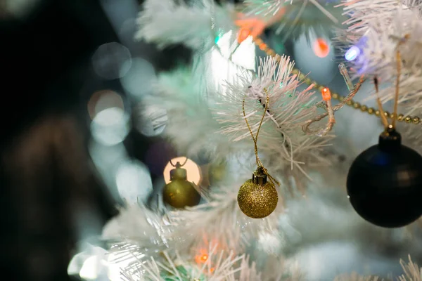 Beyaz kabarık Noel ağacında altın ve siyah Noel topları — Stok fotoğraf