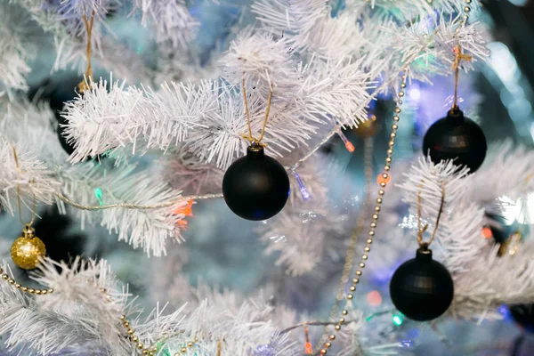Boules de Noël dorées et noires sur un sapin de Noël moelleux blanc — Photo