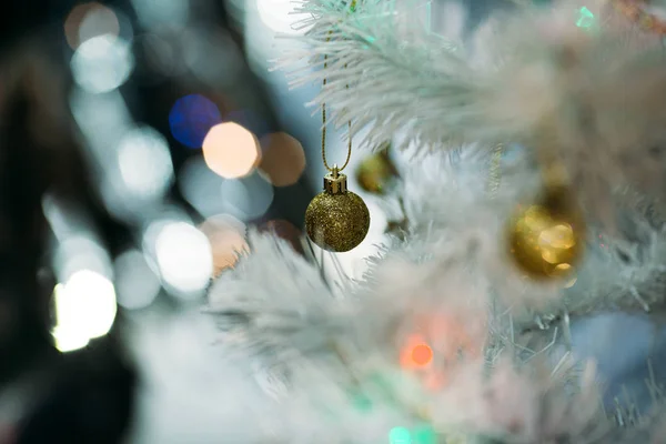 Goldene Weihnachtskugeln auf einem weißen, flauschigen Weihnachtsbaum — Stockfoto