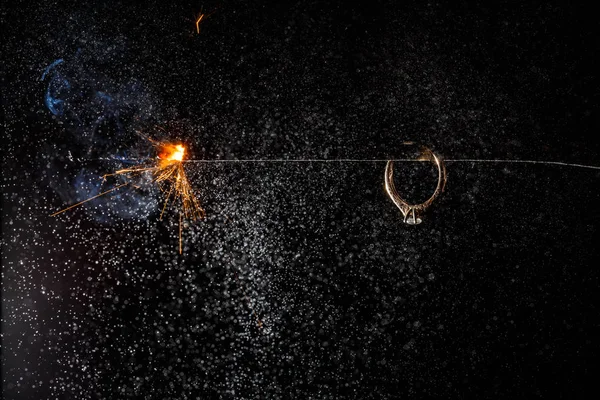 Anillo de compromiso de boda en la luz de bengala ardiente — Foto de Stock