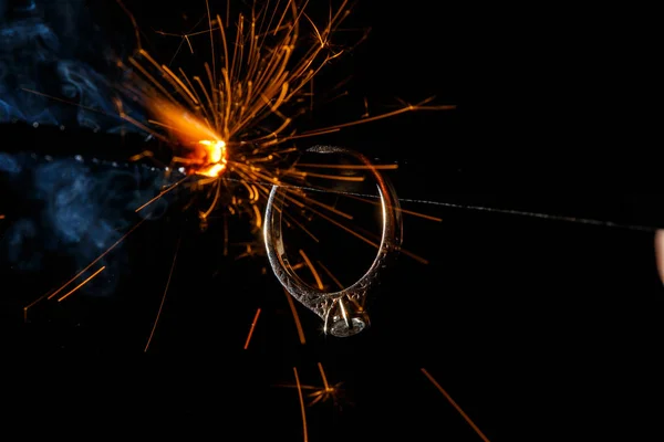 Anillo de compromiso de boda en la luz de bengala ardiente — Foto de Stock