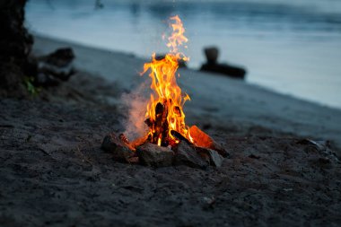 Şenlik ateşi bir gölün kumlu plajında yakılır.