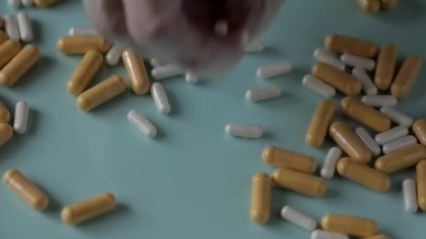 Руки, одягнені в гумові стерильні медичні рукавички, підбирають таблетки — стокове відео