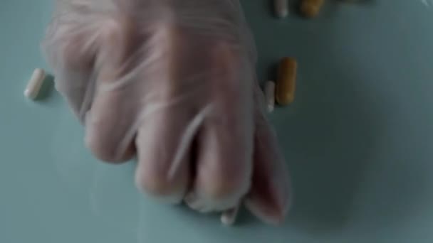 Hands dressed in rubber sterile medical gloves picks the pills — Stock Video