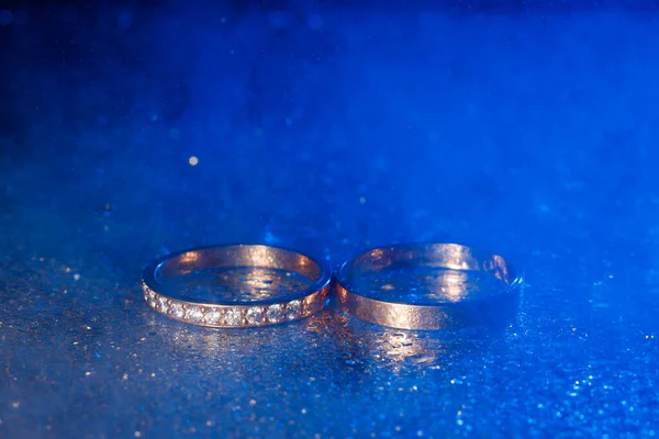 Pair Gold Wedding Rings Blue Neon Bokeh Background Smoke — Stock Photo, Image