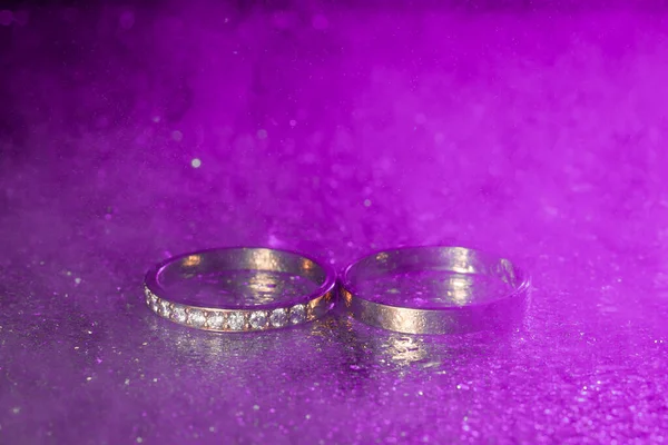 Pair Gold Wedding Rings Blue Neon Bokeh Background Smoke — Stock Photo, Image