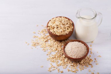 Vegan sigara süt yulaf süt un ve beyaz ahşap arka plan sağlıklı beslenme üzerinde pul