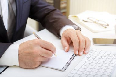 Modern bilgisayar kullanma ve bir not defteri iş kavramı yazma erkek el yakın çekim