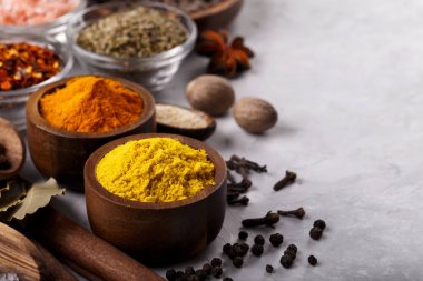 Gri taş zemin üzerinde baharatlar ve bitkiler menü veya tarifler için boş alan olan makroyu kapatın