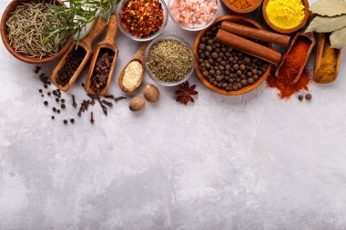 Gri taş arkaplan üzerinde baharatlar ve bitkiler menü veya tarifler için boş alan ile üst görünüm