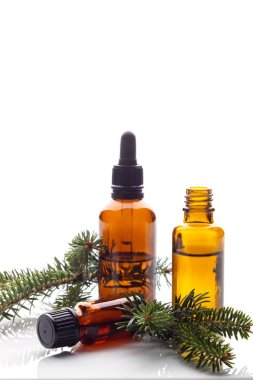 Beyaz arka planda izole edilmiş koyu renkli şişelerde çam ya da ladin yağı.