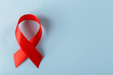 Metin Dünya Kanser Günü için mavi arkaplan boşluğunda kırmızı kurdele