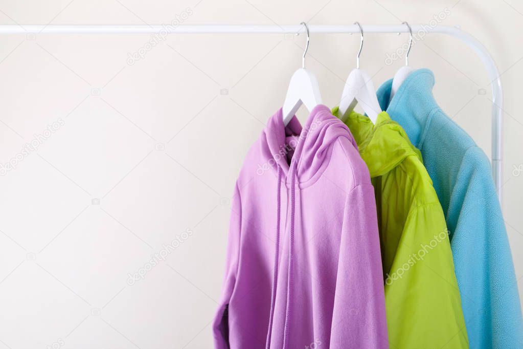 Colorful vivid sports hoodie and T-shirt hanging on a rack, trendy colors and fashion concept