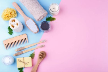 Sıfır atık tekrar kullanılabilir banyo öğeleri mavi pembe arka plan, ahşap tarak, diş fırçası, deniz süngeri, kulak çubuğu, katı sabun, shea veya hindistan cevizi yağı, düz kopya alanı