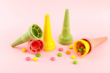 Waffle çıtır çıtır çok renkli dondurma külahları ve pembe arka planda tatlılar, boşluğu kopyala
