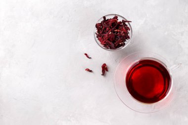 Gri taş masa üzerinde şeffaf bardakta sağIıklı amber çayı.